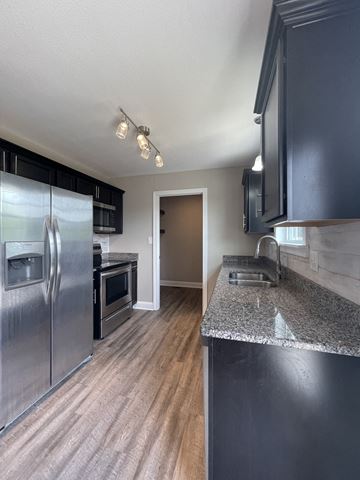 Oak Grove house for rent - A kitchen with a granite counter and stainless steel appliances.