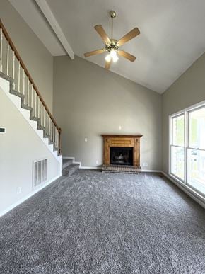 Clarksville house for rent - A living room with a fireplace and a ceiling fan.