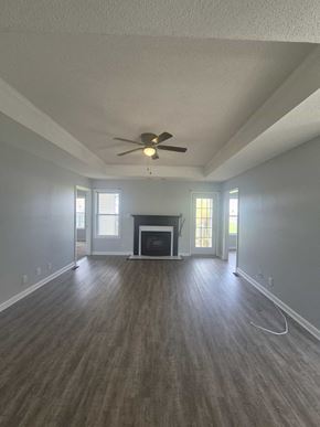 Clarksville house for rent - A spacious room with a fireplace and a ceiling fan.