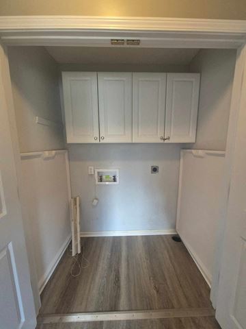 Clarksville house for rent - A kitchen with white cabinets and wood flooring.