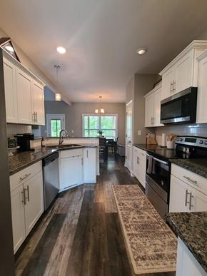 Clarksville house for rent - A kitchen with white cabinets and a black stove top oven.