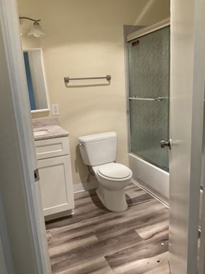 San Diego apartment for rent - A white toilet in a bathroom with a glass shower door.