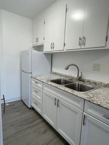 San Diego apartment for rent - A kitchen with white cabinets and a granite countertop.