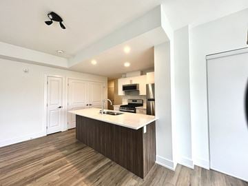 Kanata apartment for rent - A kitchen with a white counter top and wooden flooring.