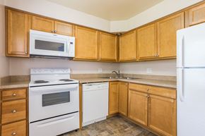 Delaware apartment for rent - a kitchen with white appliances and wooden cabinets