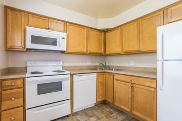 Delaware apartment for rent - A kitchen with wooden cabinets and white appliances.