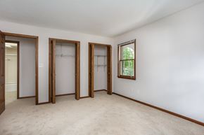 Delaware apartment for rent - a bedroom with three doors and a carpet floor and white walls