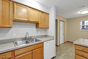 Delaware apartment for rent - A kitchen with wooden cabinets and a white dishwasher.