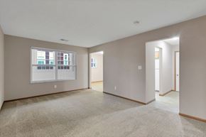 Delaware apartment for rent - A spacious room with a carpeted floor and a window with blinds.