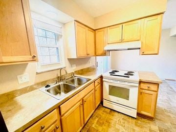 Delaware apartment for rent - a kitchen with wooden cabinets and a stove and sink