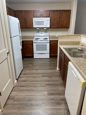 Milledgeville apartment for rent - a kitchen with white appliances and wooden cabinets