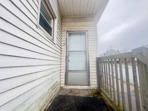 Stellarton apartment for rent - a door on the side of a white house with a wooden fence