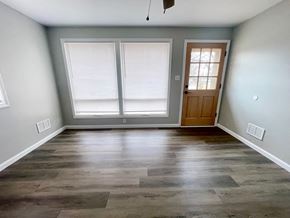 Louisville house for rent - an empty living room with wood floors and a door