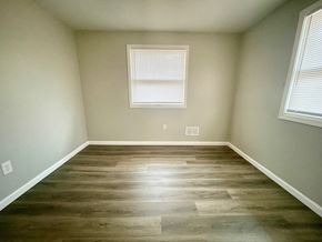 Louisville house for rent - a empty room with wooden floors and two windows