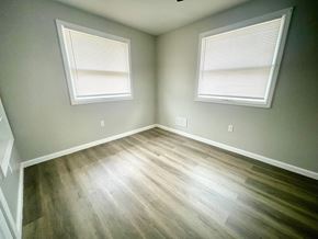Louisville house for rent - an empty room with wood floors and two windows