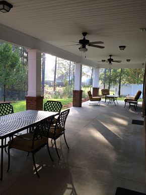 Hahira apartment for rent - a covered porch with a table and chairs and ceiling fans
