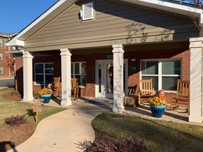 Columbus apartment for rent - front porch of a brick house with rocking chairs and potted plants