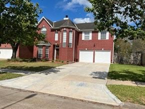 Sugar Land house for rent - a red brick house with a white garage door