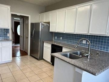 Sugar Land house for rent - a kitchen with a sink and a refrigerator