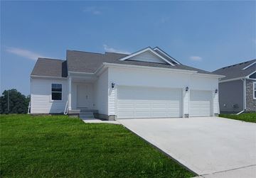 Waukee house for rent - a white house with a driveway and a garage door