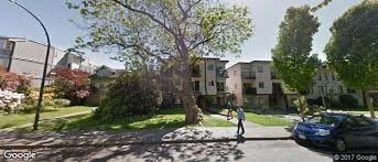 Vancouver apartment for rent - A street view of a residential area with a blue car parked on the side of the road.
