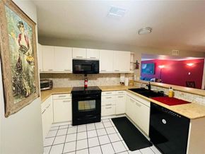 Austin apartment for rent - a kitchen with white cabinets and black appliances
