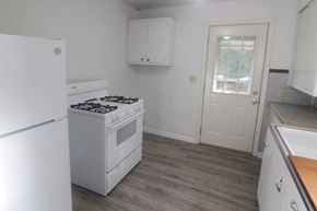 Pittsburgh house for rent - an empty kitchen with white appliances and a white door