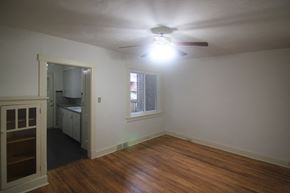 Pittsburgh house for rent - an empty living room with a ceiling fan and a window