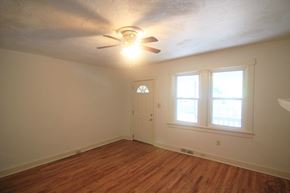 Pittsburgh house for rent - a bedroom with a ceiling fan and a door and a window
