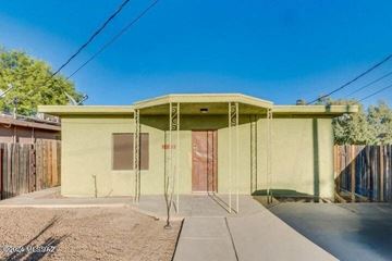 Tucson house for rent - a small yellow house with a driveway and a door
