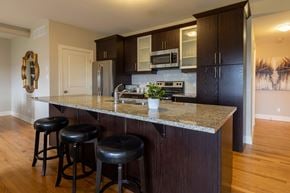 Stittsville apartment for rent - A kitchen with a granite countertop and black bar stools.