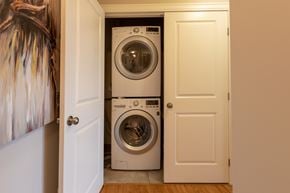 Stittsville apartment for rent - A white door is open to reveal a white washing machine in a laundry room.