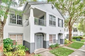 Orlando apartment for rent - the front of a white house with a porch and a blue door