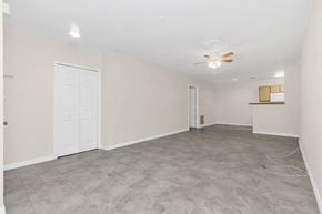 Orlando apartment for rent - an empty living room and kitchen with a ceiling fan