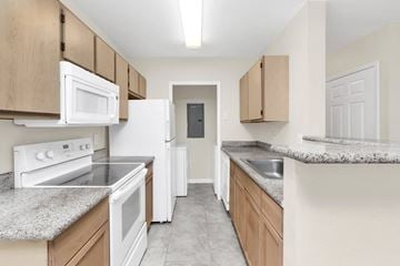Orlando apartment for rent - an empty kitchen with white appliances and granite counter tops