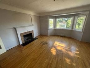 Victoria apartment for rent - a living room with a wood floor and a fireplace