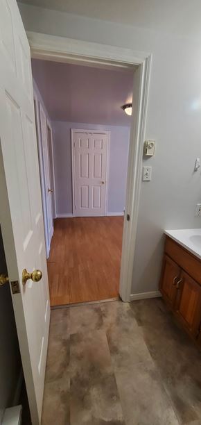 Pictou apartment for rent - A white door with a gold handle is open to a room with a white wall and a white door with a white frame.