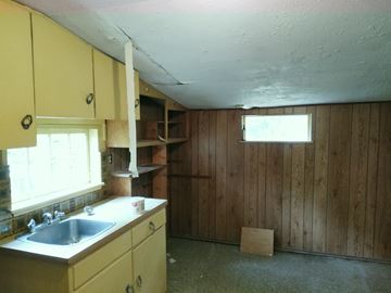 Victoria apartment for rent - an empty kitchen with a sink and a window