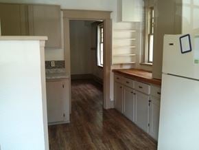 Victoria apartment for rent - an empty kitchen with wooden floors and white cabinets