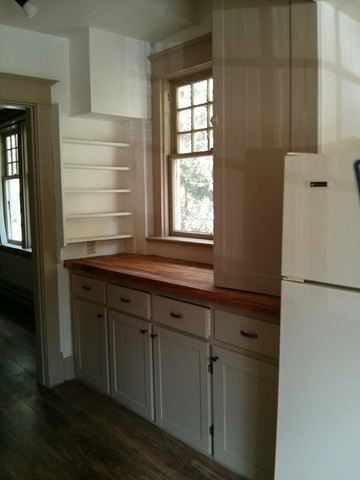 Victoria apartment for rent - a kitchen with white cabinets and a wooden counter top