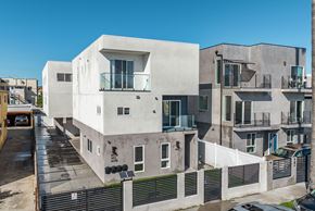 Los Angeles apartment for rent - a white apartment building with balconies and a parking lot