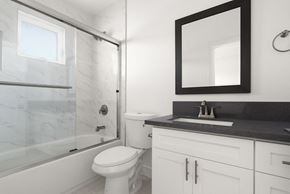 Los Angeles apartment for rent - A bathroom with a toilet, sink, and mirror.