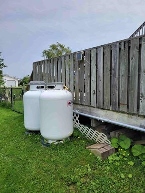 Westville apartment for rent - Two white containers are placed on the grass next to a wooden fence.