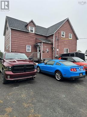 Westville apartment for rent - A red truck and a blue car are parked in front of a wooden house.