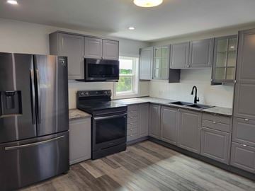 Westville apartment for rent - A kitchen with a stainless steel refrigerator and black oven.
