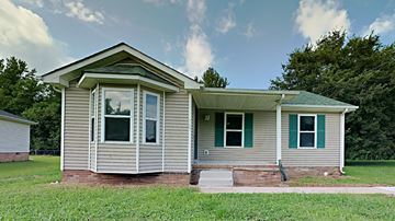 Clarksville house for rent - a small gray house with green shutters and grass and trees