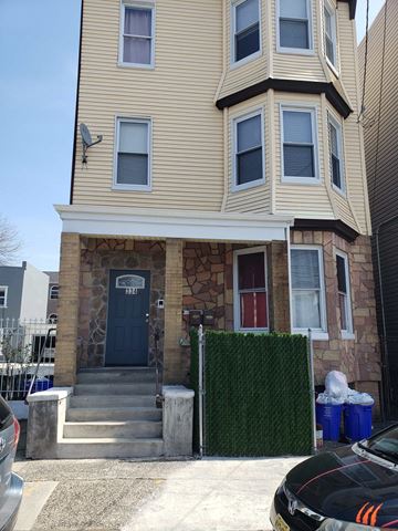 Newark apartment for rent - A two-story house with a blue door and a stone wall.