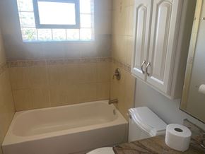 Wood Dale apartment for rent - A white bathroom with a tub, toilet, and sink.
