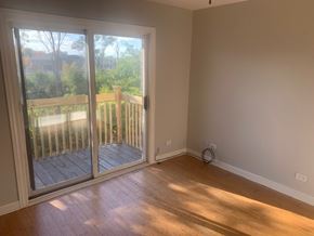 Wood Dale apartment for rent - A room with a wooden floor and a sliding glass door leading to a deck.