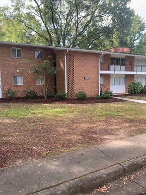 Raleigh apartment for rent - A red brick apartment building with a white door and windows.